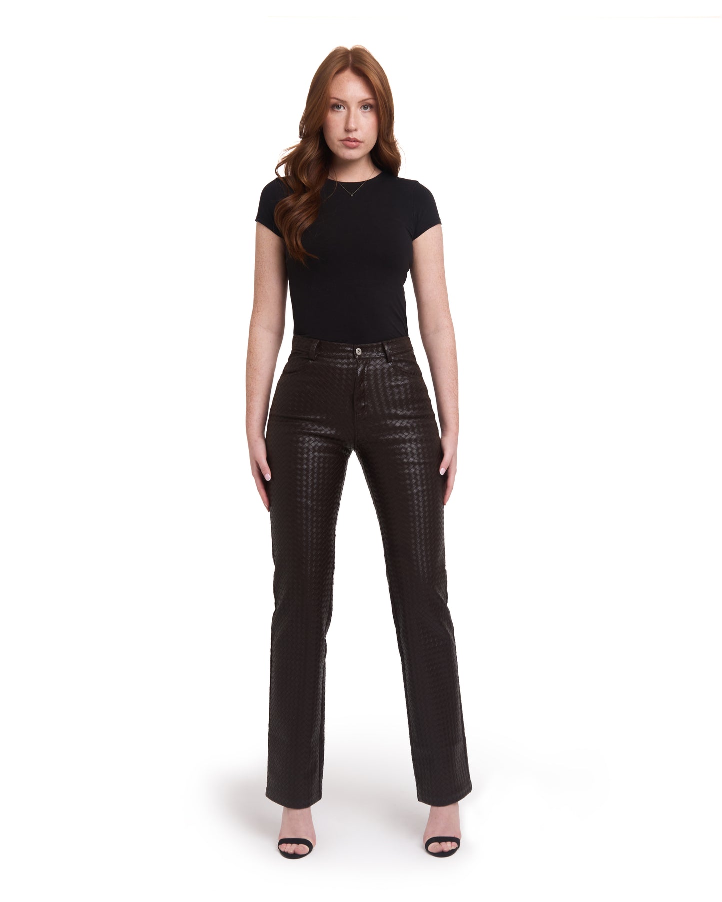 A pair of tall woven leather trousers in deep brown color, with a straight leg design. The trousers are modeled by a person standing against a plain background.