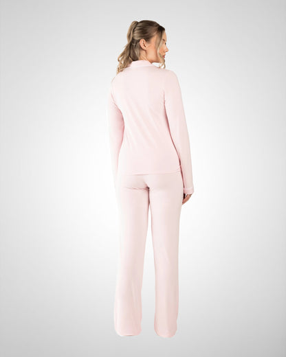 A woman wearing a light pink two-piece lounge set, viewed from the back, standing against a light gray studio background.