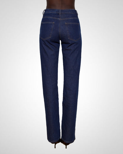 Rear view of a model wearing dark blue straight-leg denim jeans with a high waist and back pockets, shown against a light gray studio background.