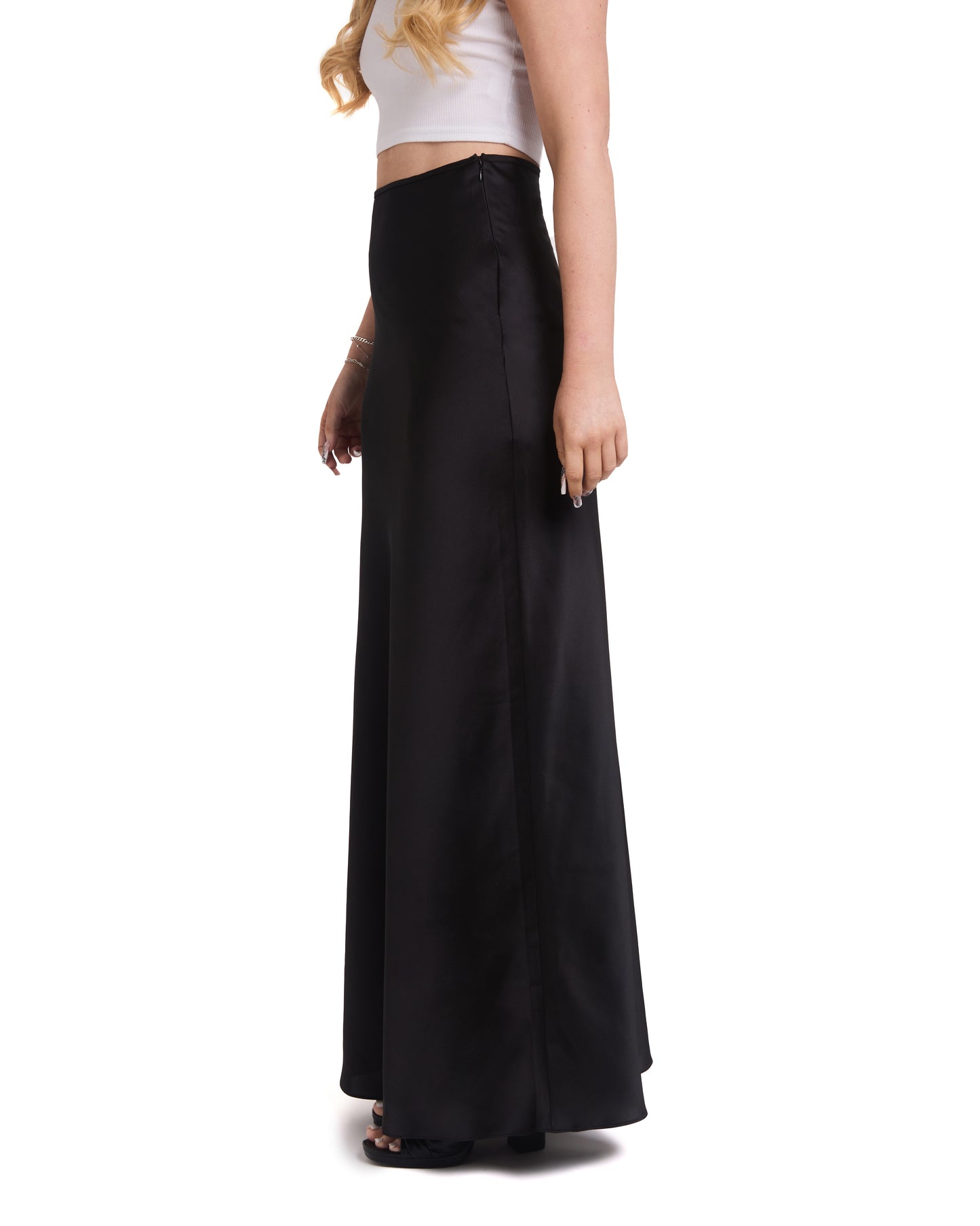 A tall model wearing a tall, high-waisted, tailored black maxi skirt with a high waist and invisible side zip. 