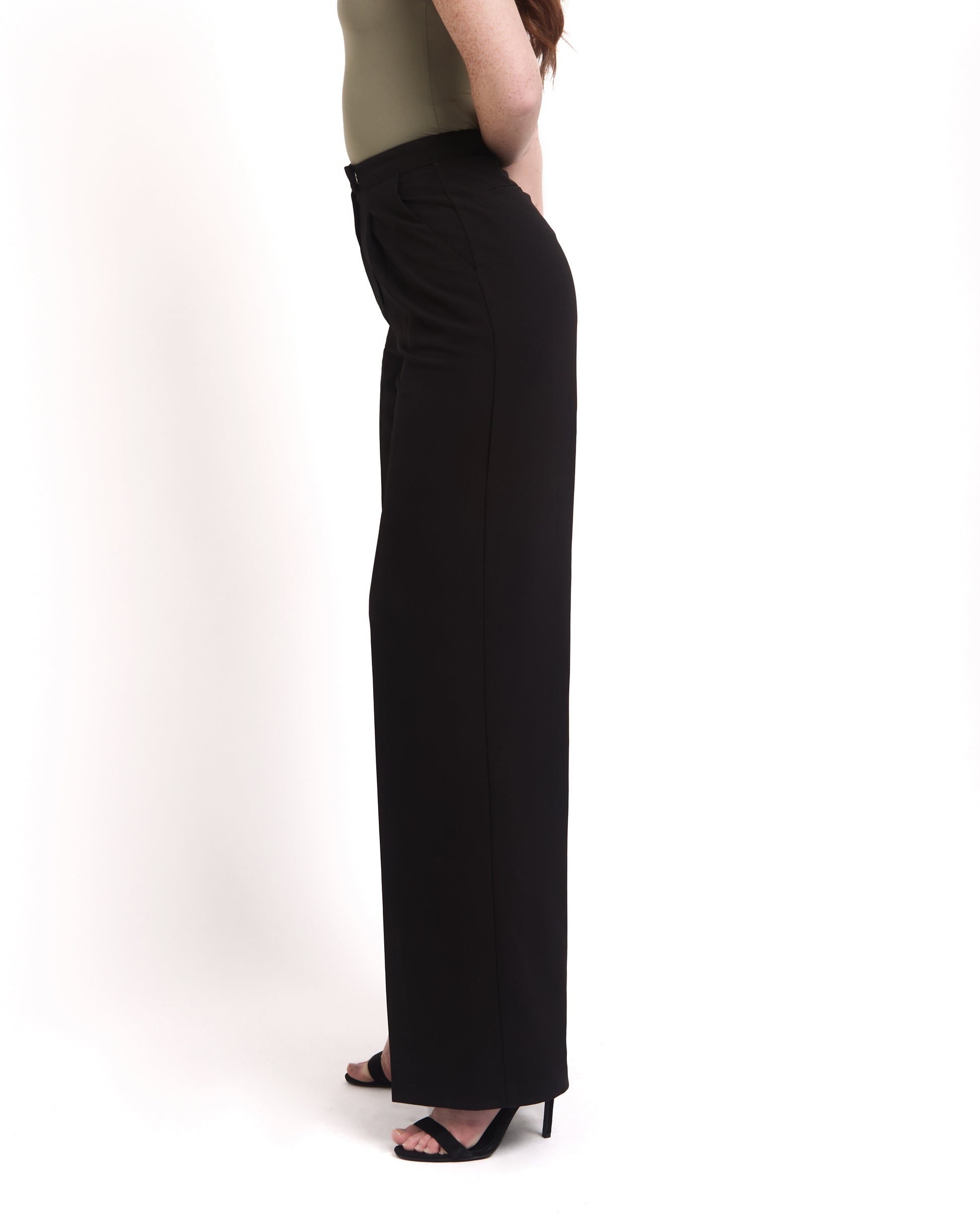 A model wearing tall wide leg tailored trousers in black with a high-waisted fit and a sleek silhouette. side shot